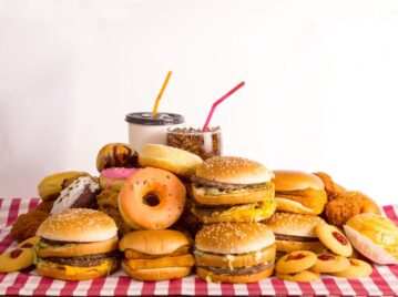 comida rápida hamburguesas donas y bebidas en una mesa