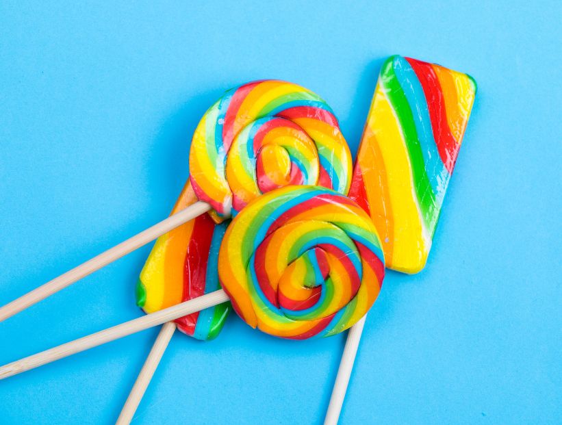 lollypops, chupetines o paletas de caramelo sobre fondo celeste