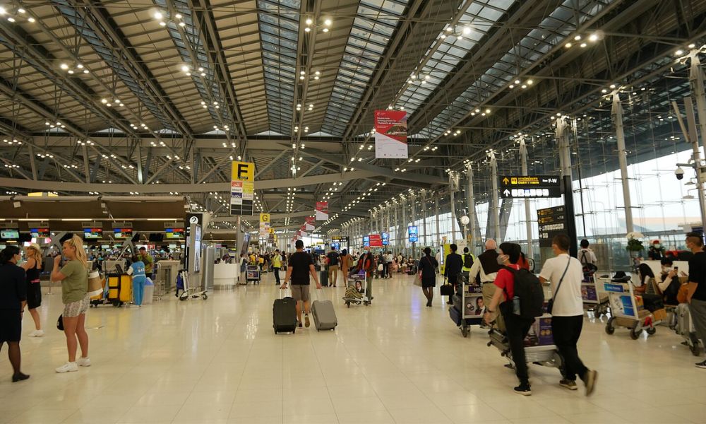 Pasajeros caminan por el aeropuerto que tiene la torre de control de tráfico aéreo más alta del mundo.