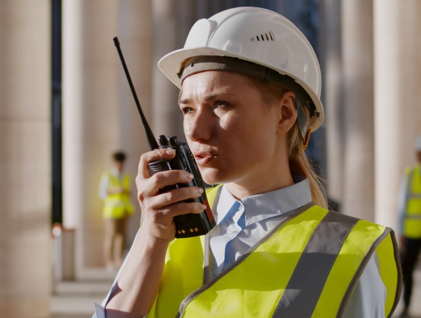 mujer constructora hablando a un walkie talkie