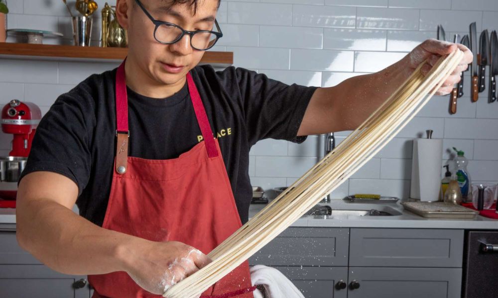 hombre haciendo fideos a mano estirando los fideos japoneses