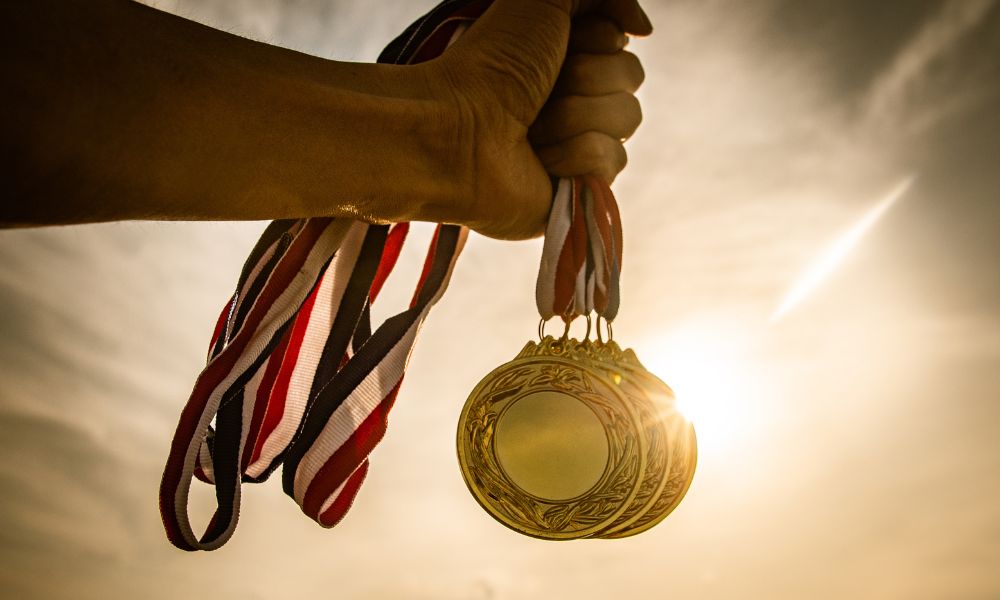 mano sosteniendo medallas de oro