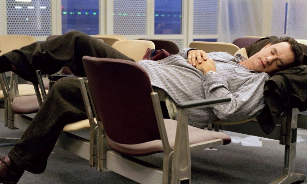 El personaje de Tom Hanks durmiendo entre bancos, tal como Nasseri. Película La Terminal