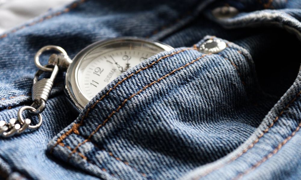 El bolsillo pequeño de un jean con un reloj.