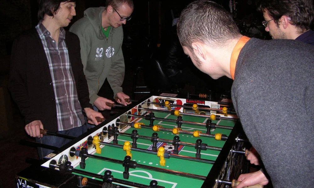 Personas disfrutan de un metegol.