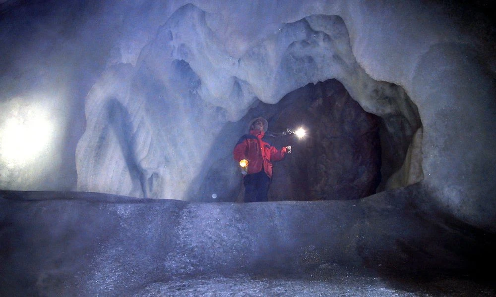 Persona en la cueva de hielo más grande del mundo.