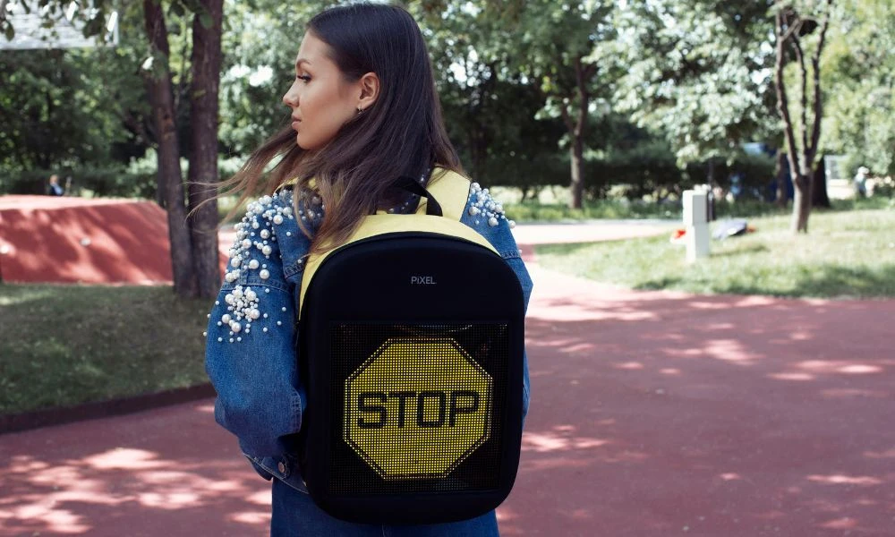 Mujer con mochila escolar.